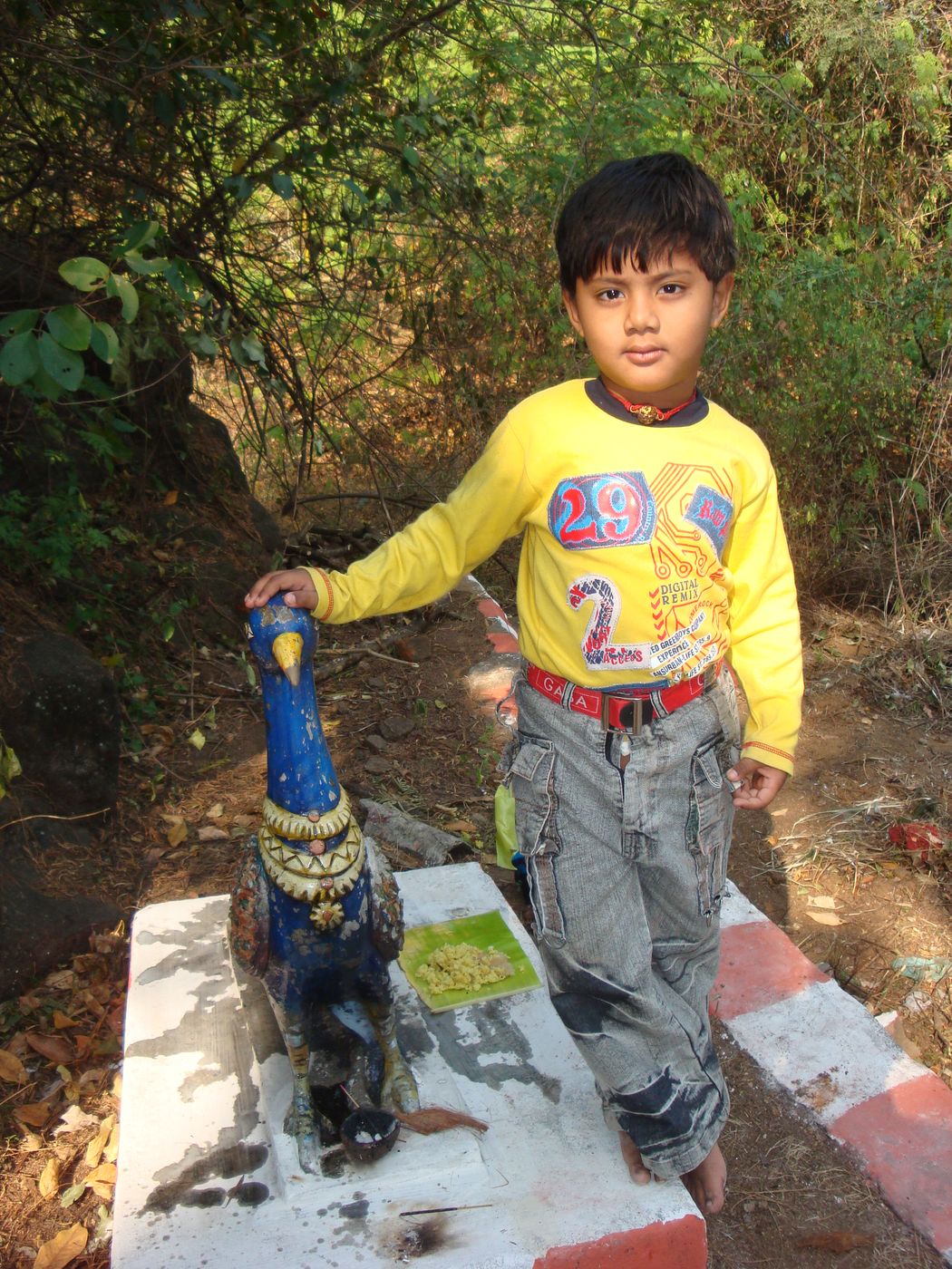 Me as a child next to a peacock statue