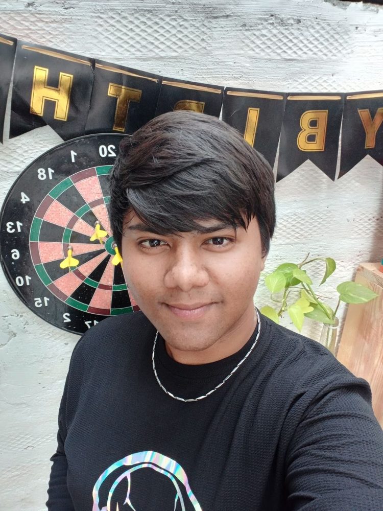 Selfie in front of a dartboard and a birthday banner