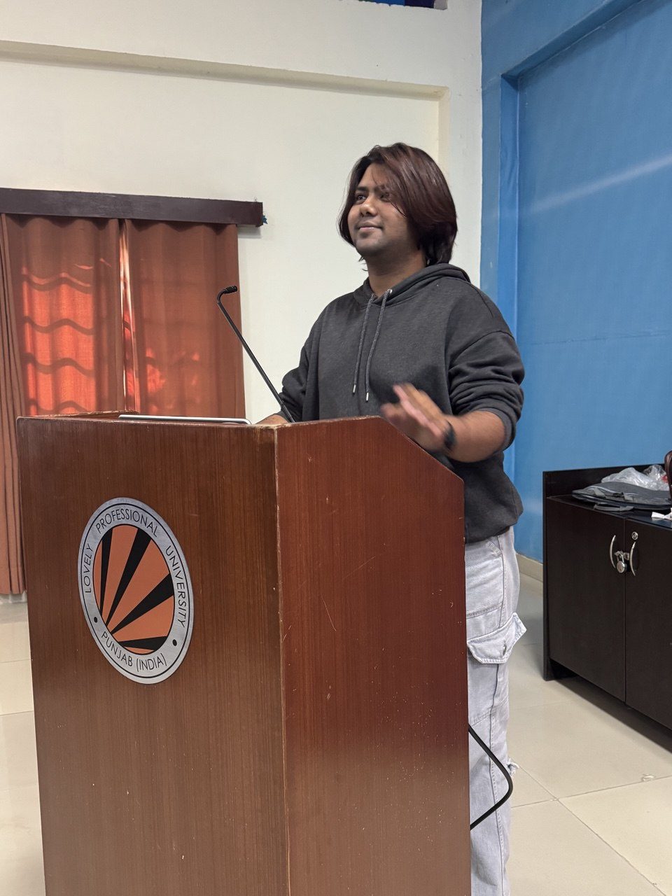 Speaking at a podium with the LPU logo