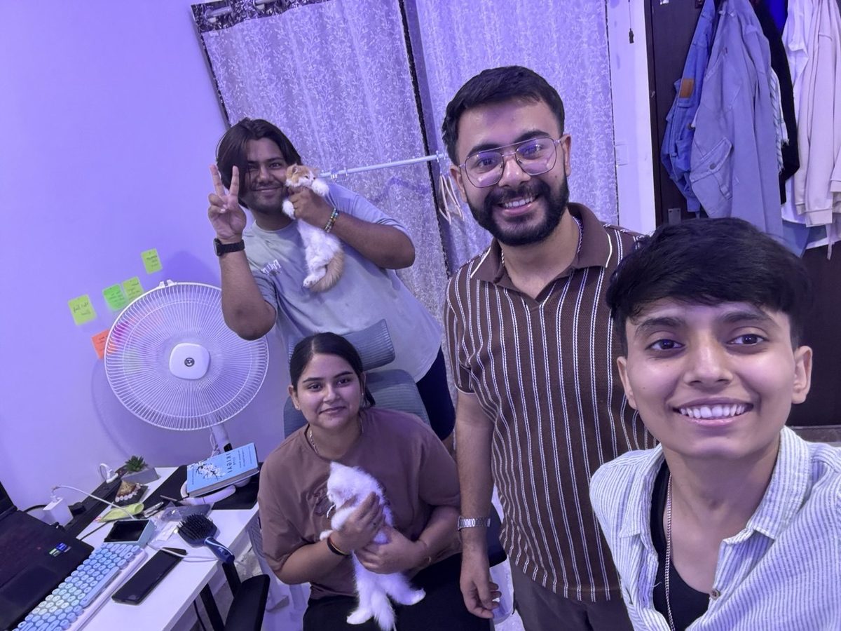 With friends in a purple lit room, holding two kittens