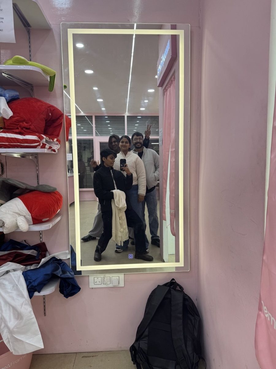 Mirror selfie of four friends in a pink shop
