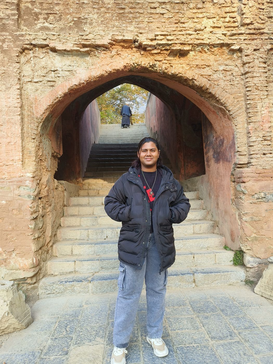 Standing under an old stone arch in Kashmir