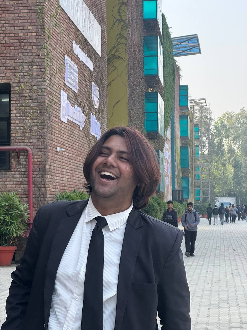 Laughing in a suit and tie on campus, from my first interview