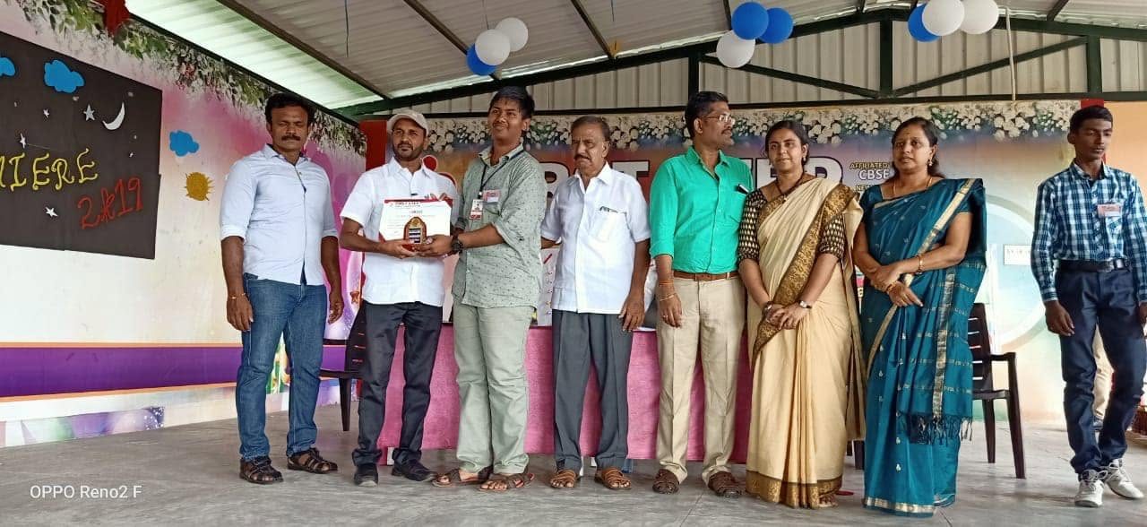 Receiving a trophy on stage at school with teachers and the principal